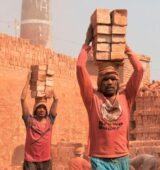 Workers carrying bricks at a construction site in Gabtoli, showcasing manual labor.