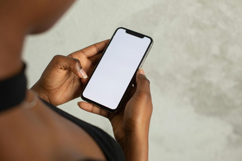 Close-up of a woman holding a smartphone with a blank screen, ideal for mock-ups and design.